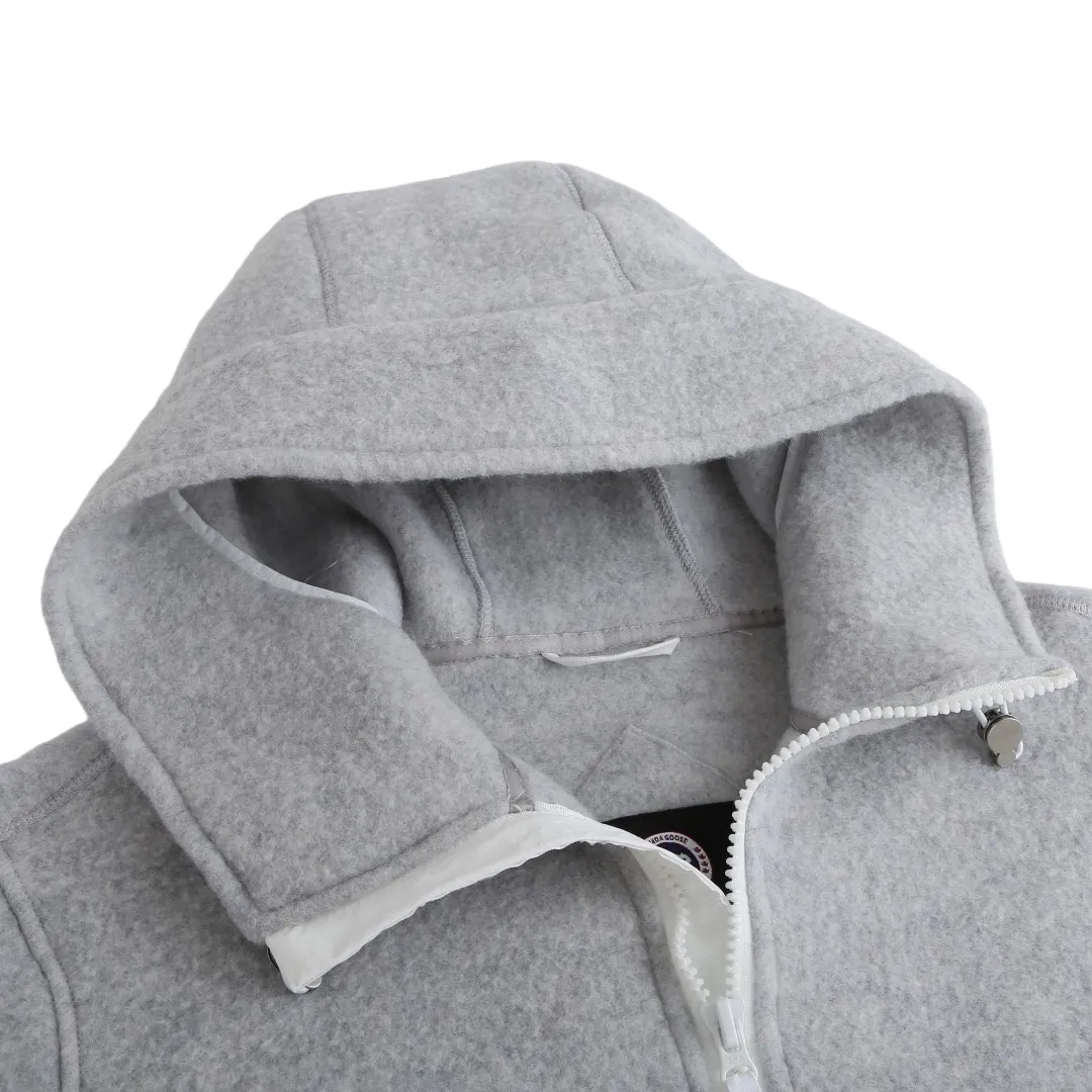 P780 Canada Goose Wool Fleece Hooded Jacket (Light Gray) The fabric is made of wool fleece fabric, which is mainly made of wool and mixed with a very small amount of spandex and polyester fiber. Wool is a core natural ingredient that provides unparalleled temperature regulation, antibacterial and anti-odor properties and a skin-friendly feel. The feeding of a small amount of spandex gives the fabric a certain degree of four-way elasticity, making it non-restrictive during daily activities. As the basis of fleece's structure, polyester fiber enhances the fabric's durability, wrinkle resistance and quick-drying properties. It contributes to the loft of the fleece and provides functions such as trapping air. The sleeves and hem are closed with 2×2 ribbing. Its strong elasticity can closely fit wrists and waists of different thicknesses, forming an effective 'seal' to prevent cold wind from blowing back. It can still maintain its original shape after repeated stretching and use, and is not easy to loose and deform. And the ribbed cuffs can convey a sense of design and enhance the visual beauty. The combination of hood design and elastic buckle improves warmth and windproof performance when worn. Size:S-M-L-XL